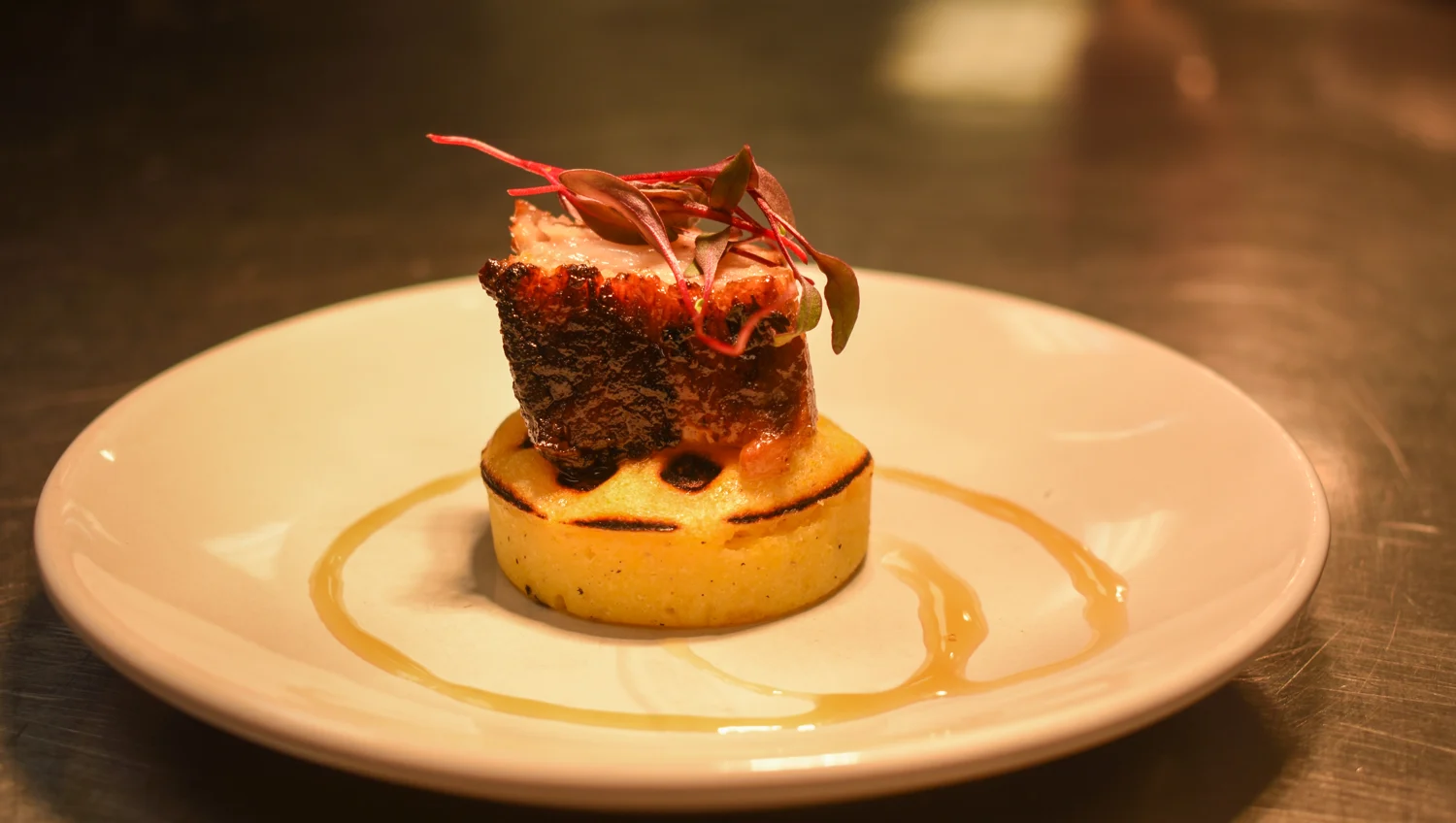 A carefully plated SPBH entrée with a golden base and delicate red garnish