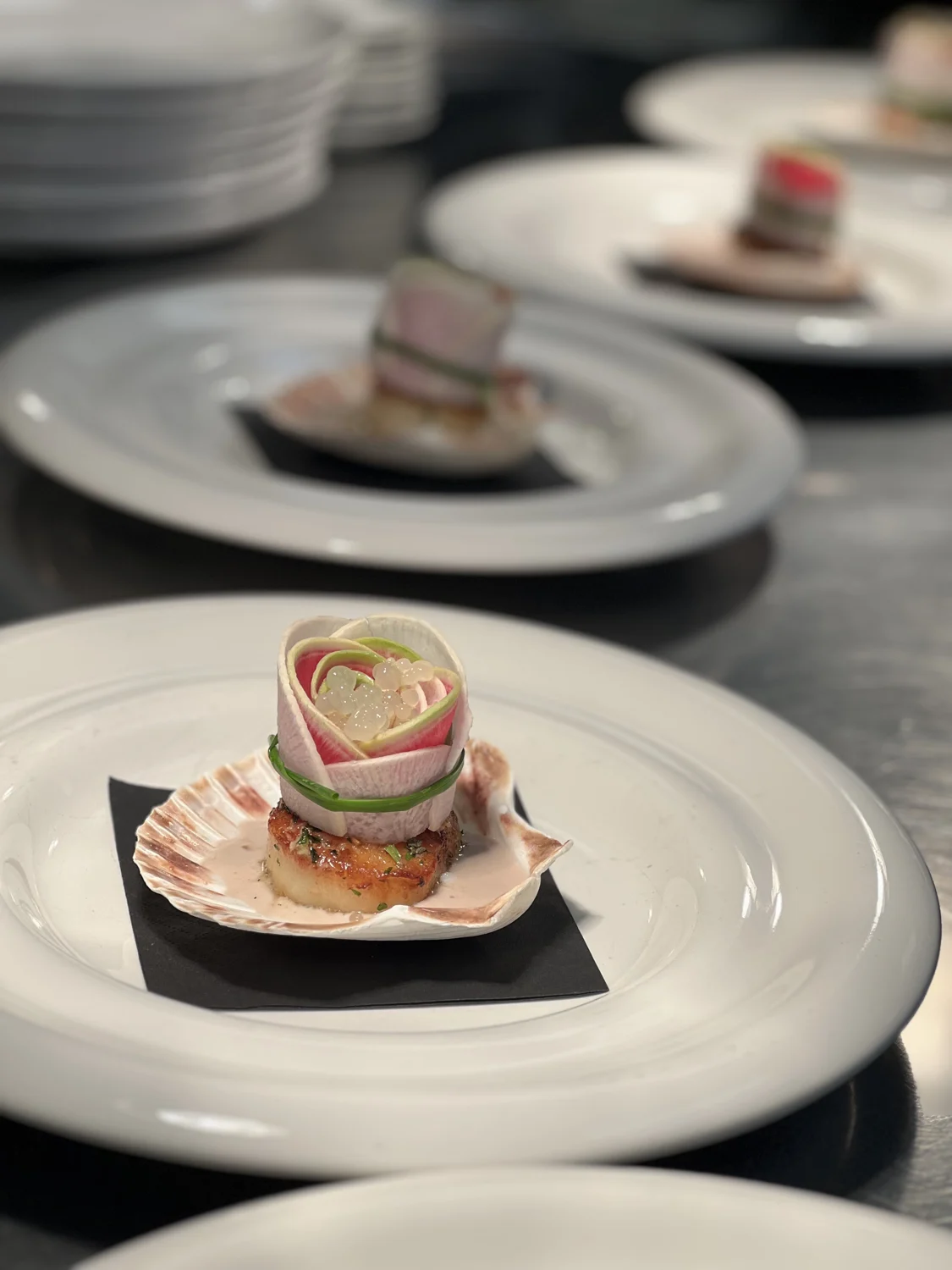 SPBH dishes lined up for service, with the front plate in sharp focus