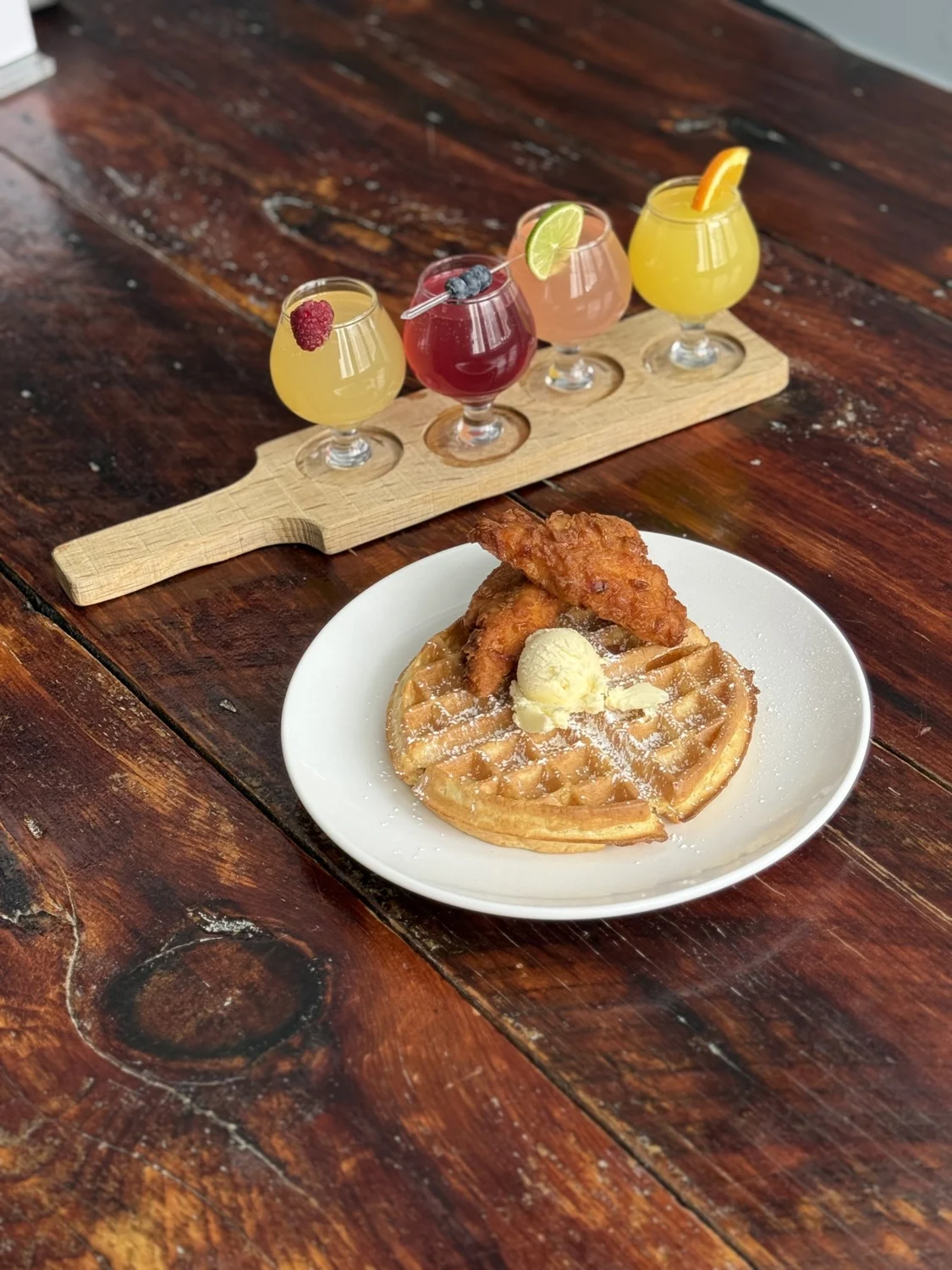 An SPBH waffle plate and colorful drinks on a wooden table