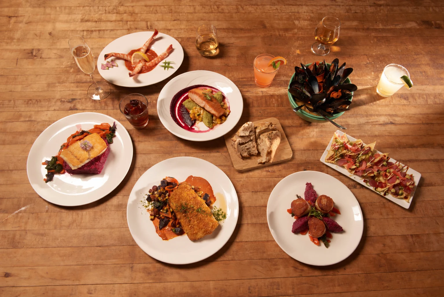 A Sandy Point dinner table with plated entrées and wine