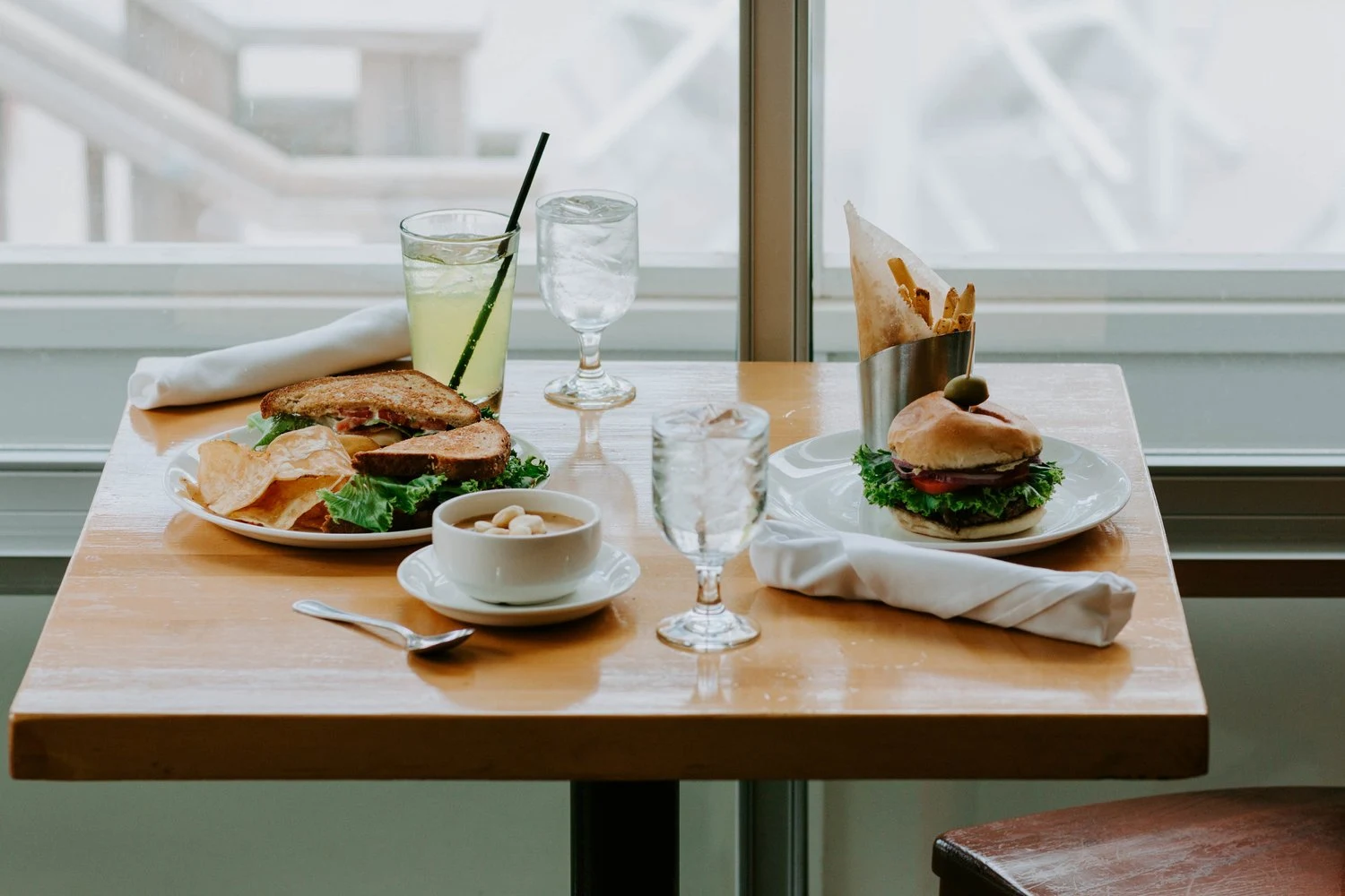 Two meals and drinks at a sunlit Sandy Point table